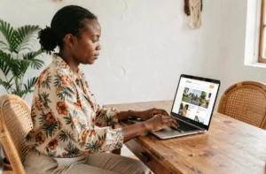 Femme malgache recherchant une maison en ligne sur une plateforme immobilière depuis son bureau à domicile